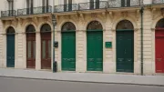 Rangée de portes colorées et toutes différentes sur une façade parisienne, vue en légère contre-plongée